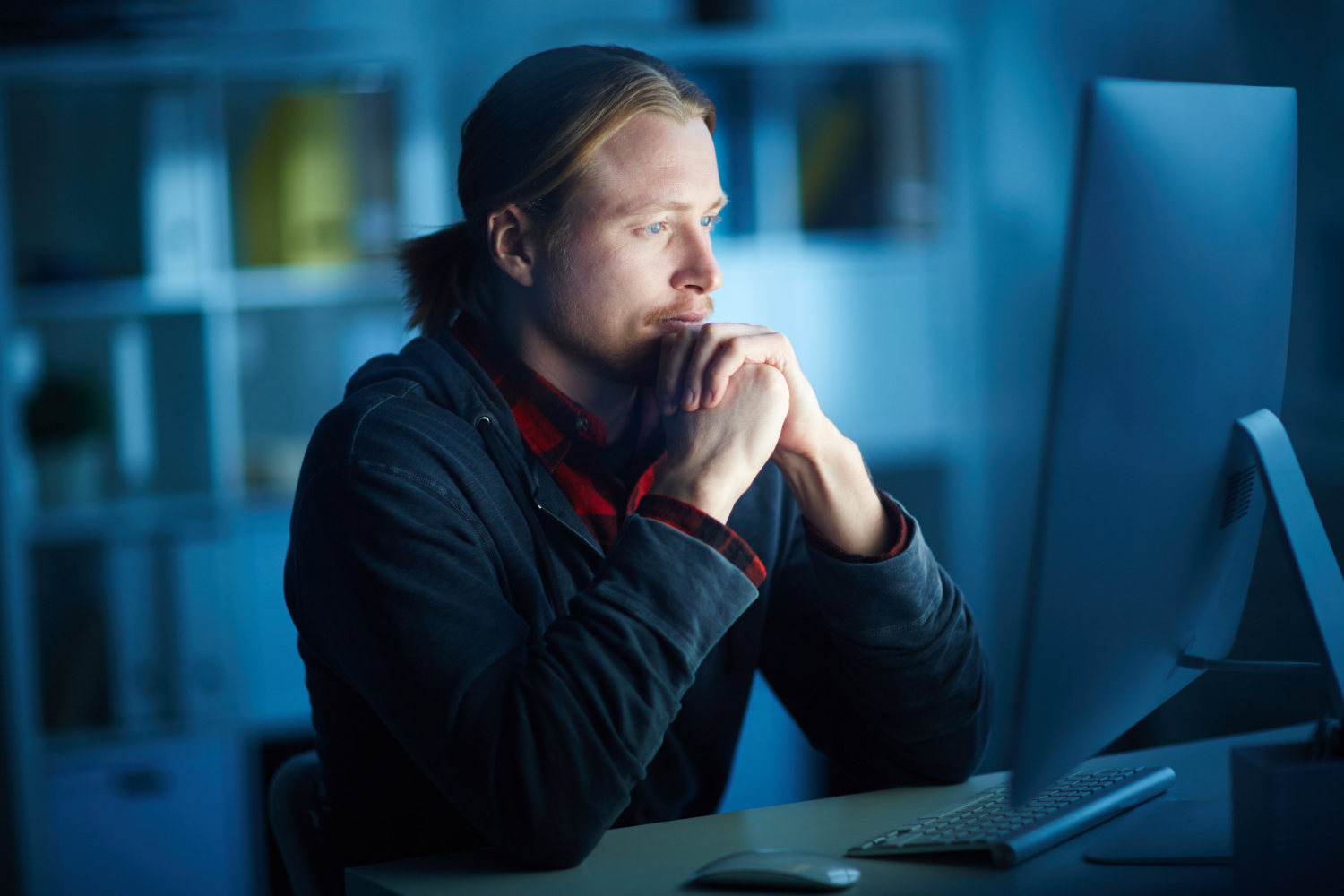 Un homme regarde un écran d'ordinateur