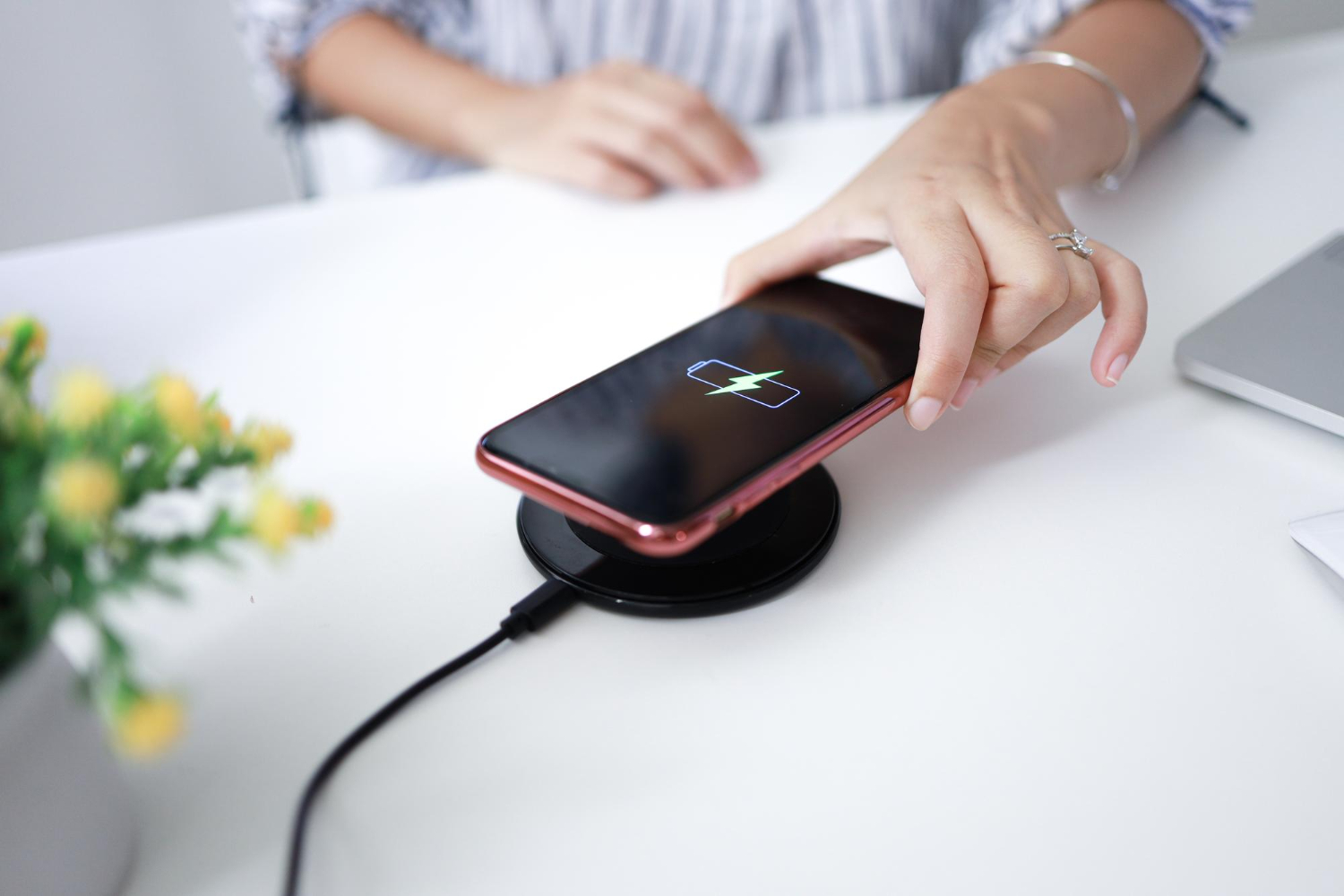 Une fille charge son téléphone sur un chargeur sans fil